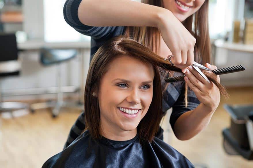 Happy salon customer receiving hair cut