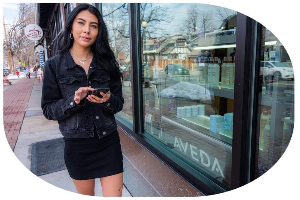 Women walking past salon with an Iphone