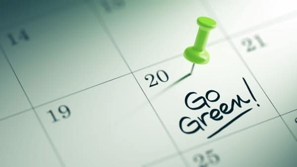 green pin on a calendar date that says go green