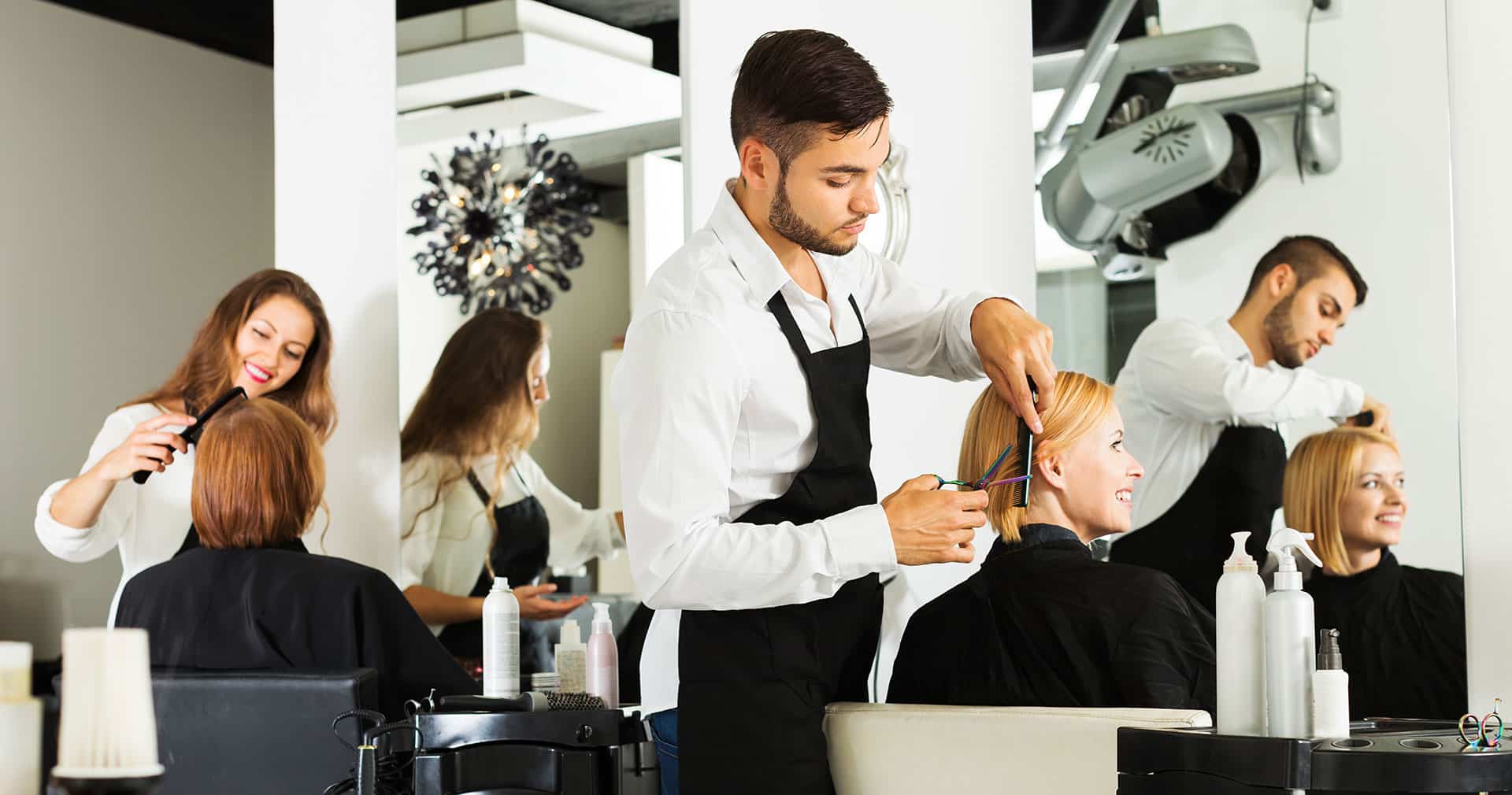 Stylists doing hair at salon stations