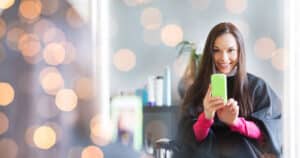 Woman taking selfie in mirror at salon