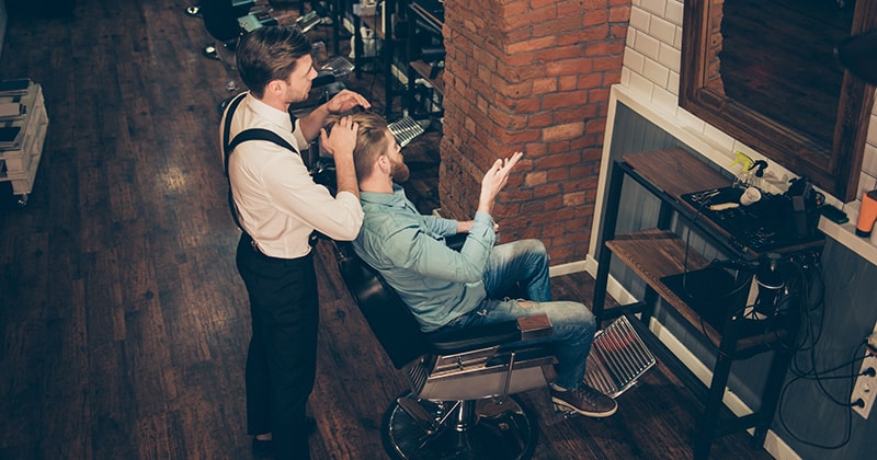 barber talking to client while they both look in a mirror