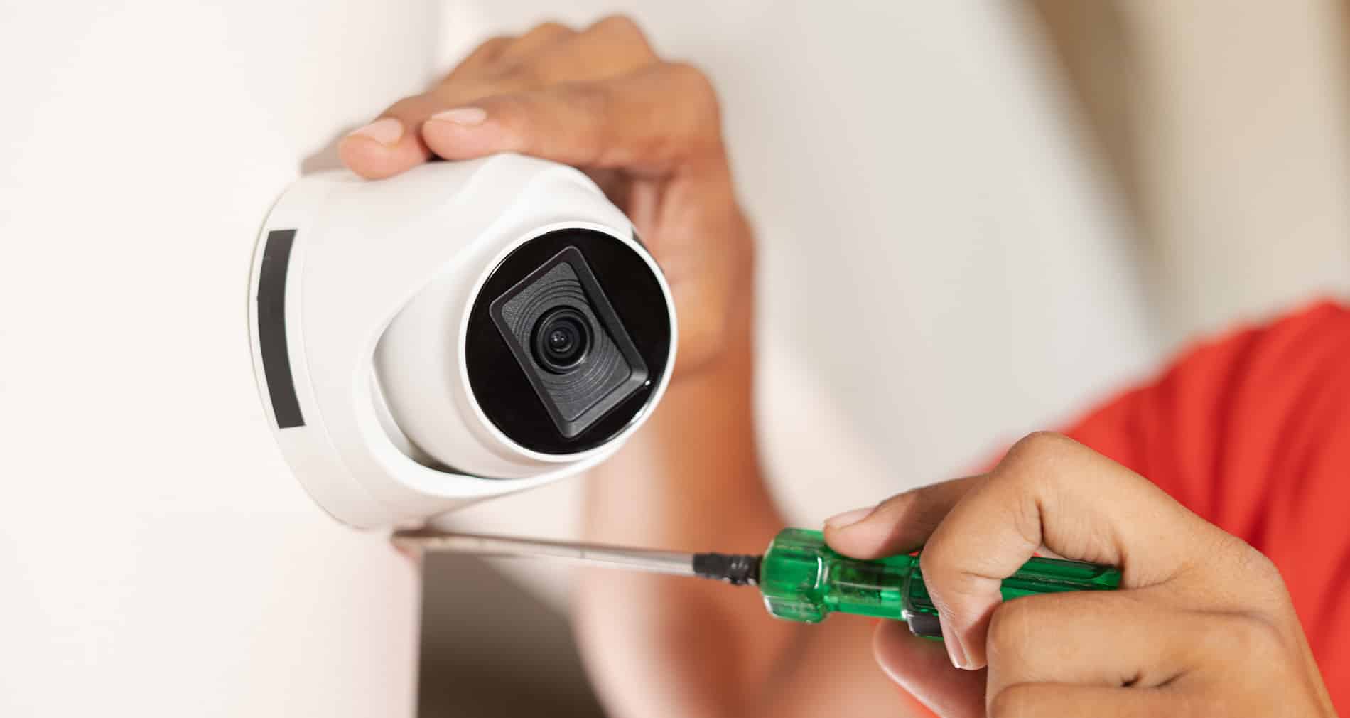 a person installing a security camera in a hair salon