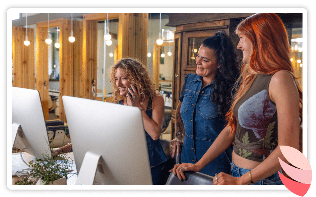 a salon team gathered around a work station