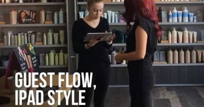 Salon employee standing with an Ipad talking to customer