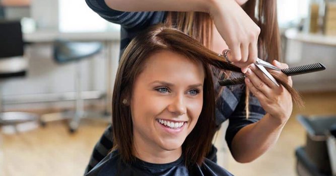 Happy salon customer receiving hair cut