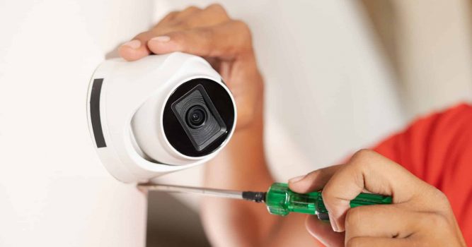 a person installing a security camera in a hair salon