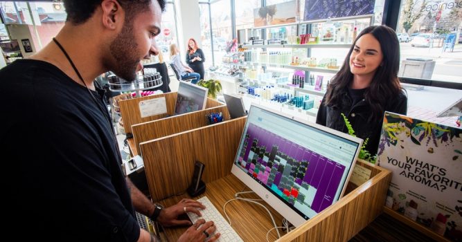 salon front desk staff looking at computer helping client