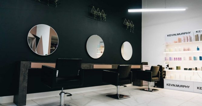 Minimal and modern salon decor ideas, a salon with round mirrors and black walls with decorative plants