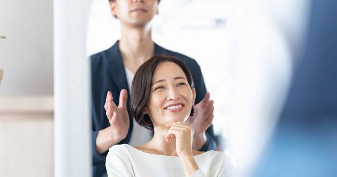 stylist frames clients hairstyle with hands looking into mirror