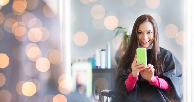 Woman taking selfie in mirror at salon