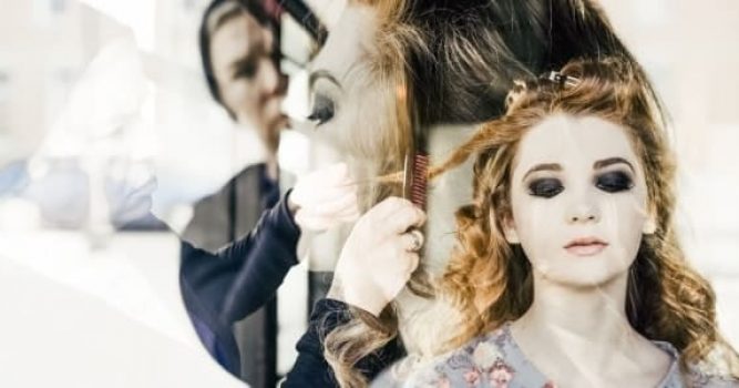 Woman getting her hair brushed and curled in a salon