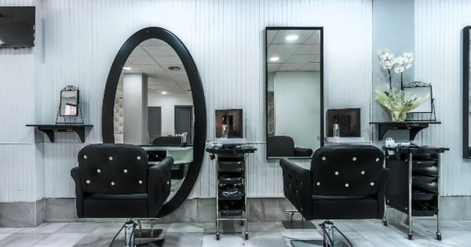 two chairs in front of a mirror inside a hair salon