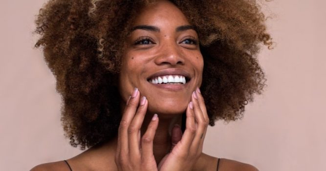 woman smiling holding her jaw